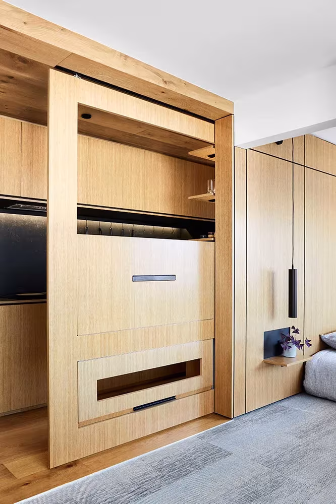 Panel corredero de roble que cierra la cocina del apartamento de Jack Chen en Melbourne