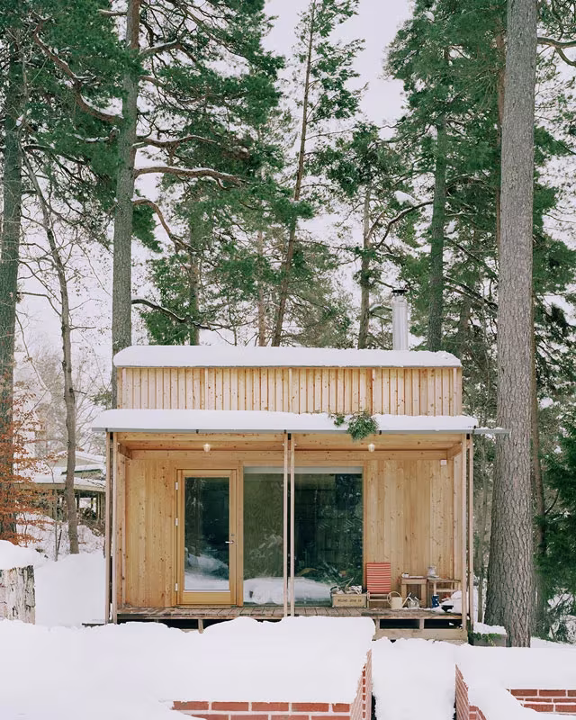 Pabellón anexo de la Villa Idun-Lee cubierto de nieve entre los pinos del archipiélago de Estocolmo
