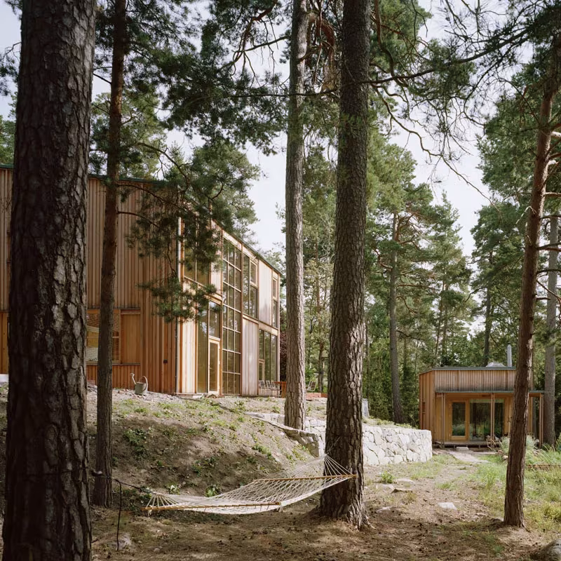 Casa de madera entre los pinos con hamaca y pabellón anexo en la Villa Idun-Lee, en Nacka