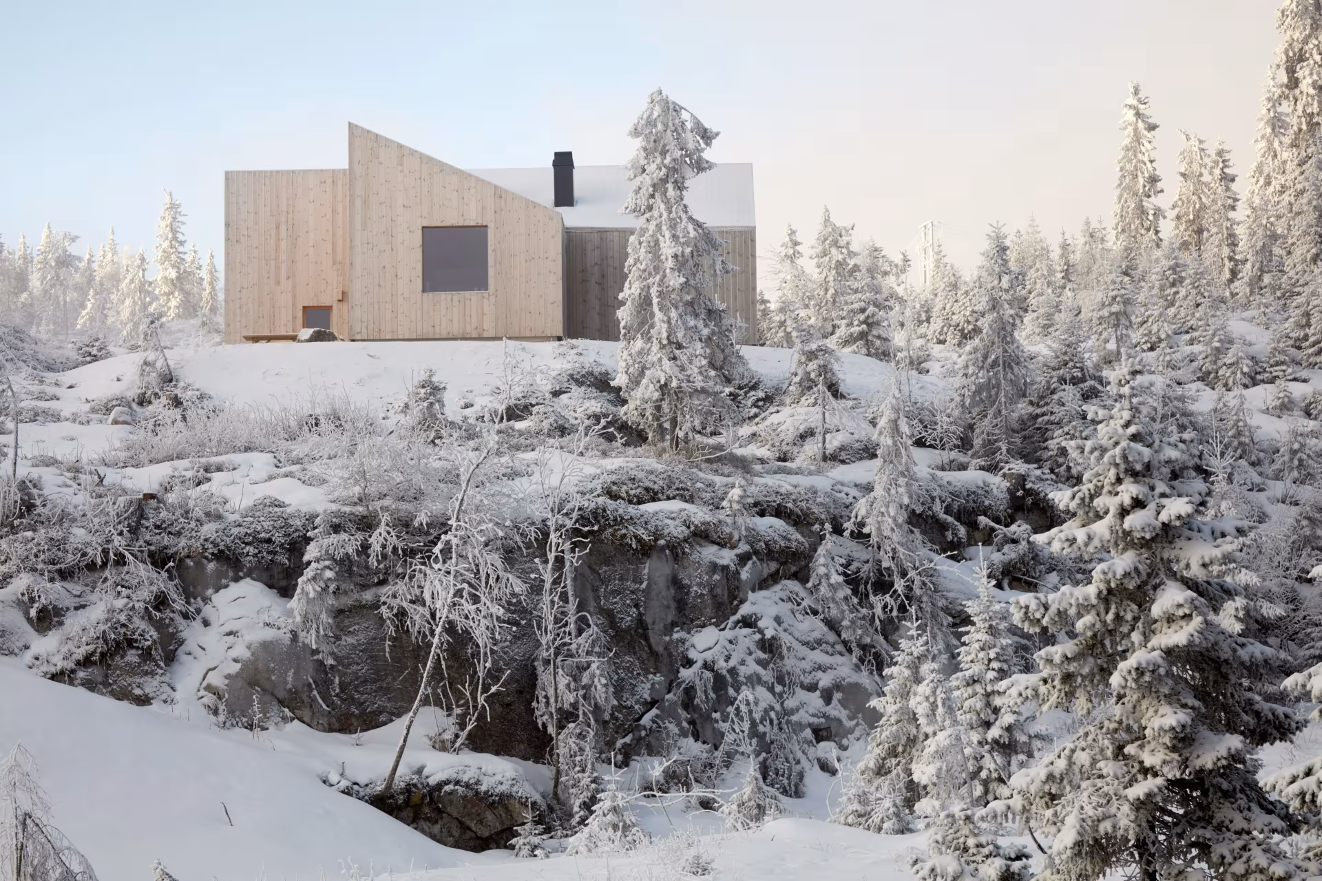 Mylla Hytte de Mork Ulnes Architects entre abetos nevados y roca, cerca de Oslo