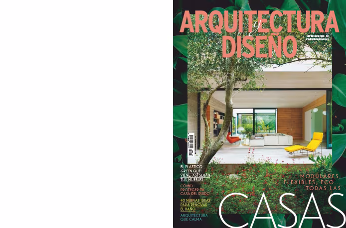 Portada de Arquitectura y Diseño con una casa de salón abierto entre vegetación y una tumbona amarilla