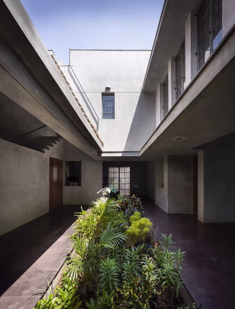 Patio longitudinal con vegetación entre dos alas de hormigón visto en Court House de Moad, Chennai, India
