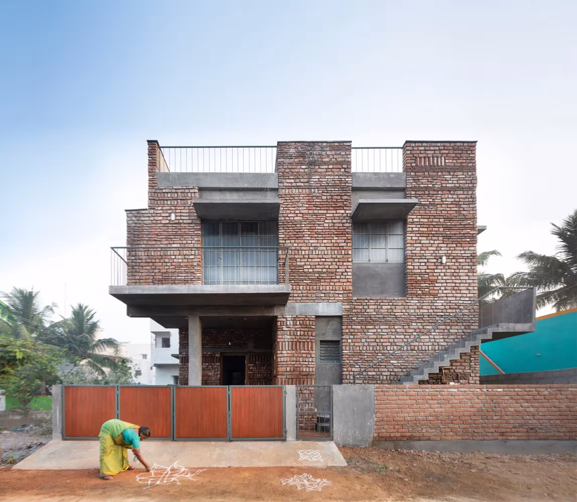 Fachada de ladrillo reciclado con balcón volado, escalera exterior y cancela de metal de Court House en Chennai