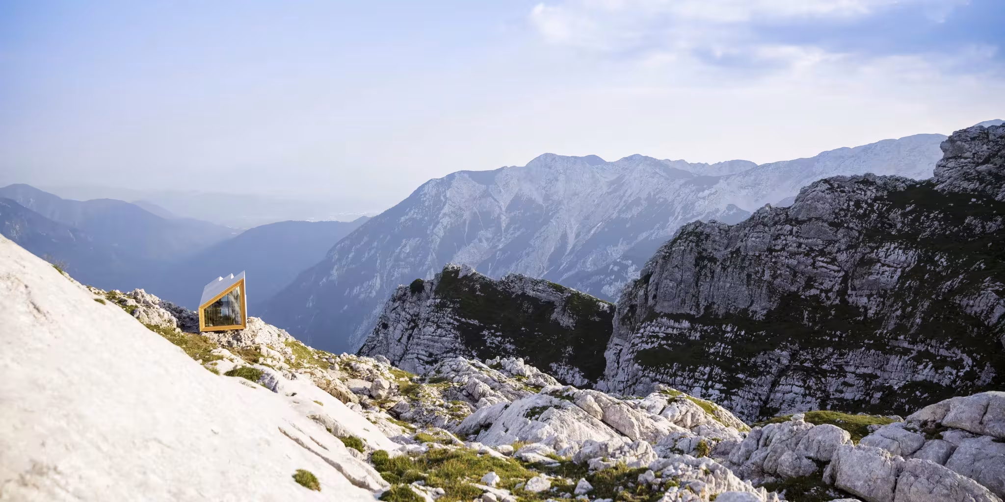 Refugio Skuta a lo lejos, sobre una ladera de roca caliza con vistas a las montañas de los Alpes eslovenos