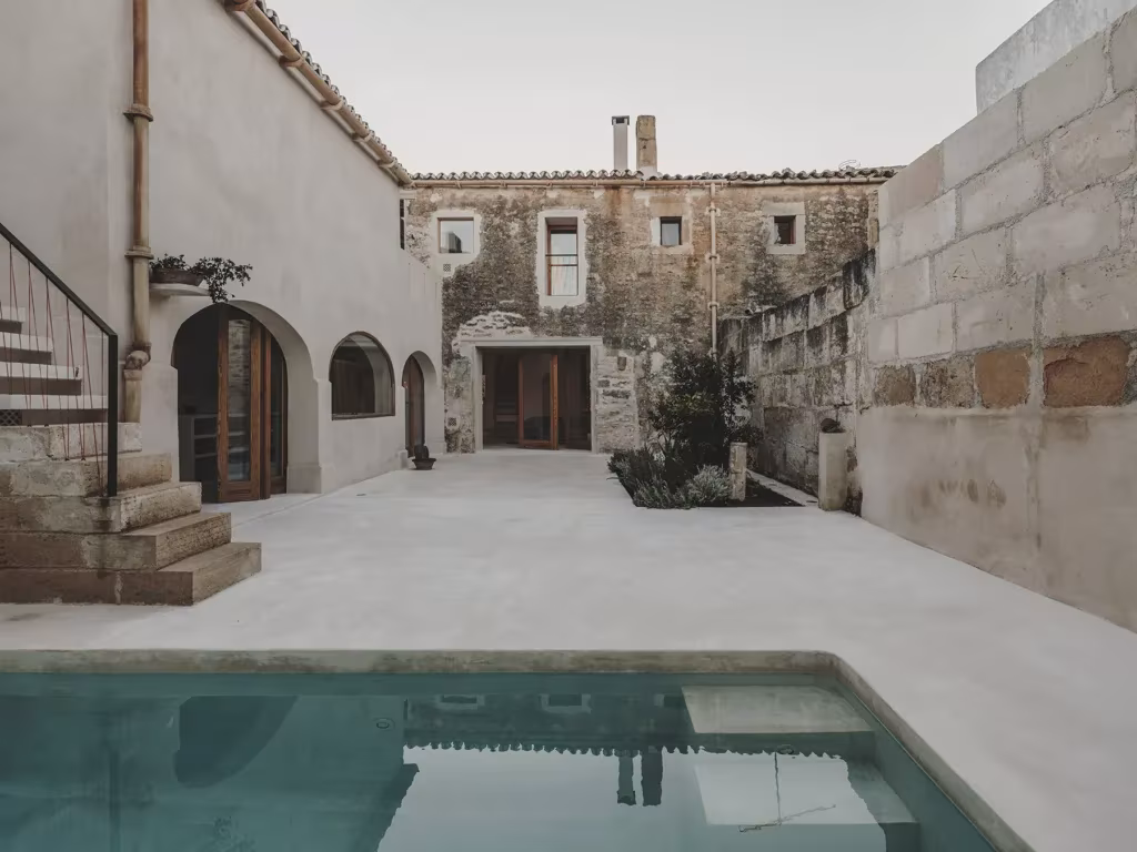 vista del patio con la piscina y la casa