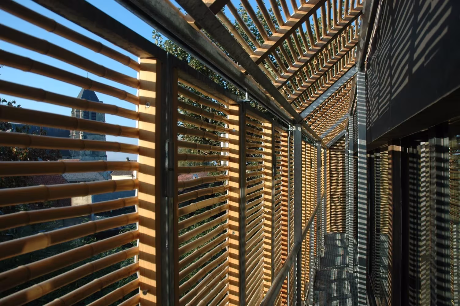 Pantalla de lamas de madera sobre la fachada acristalada de la Maison Bambou de Karawitz Architecture, Bessancourt