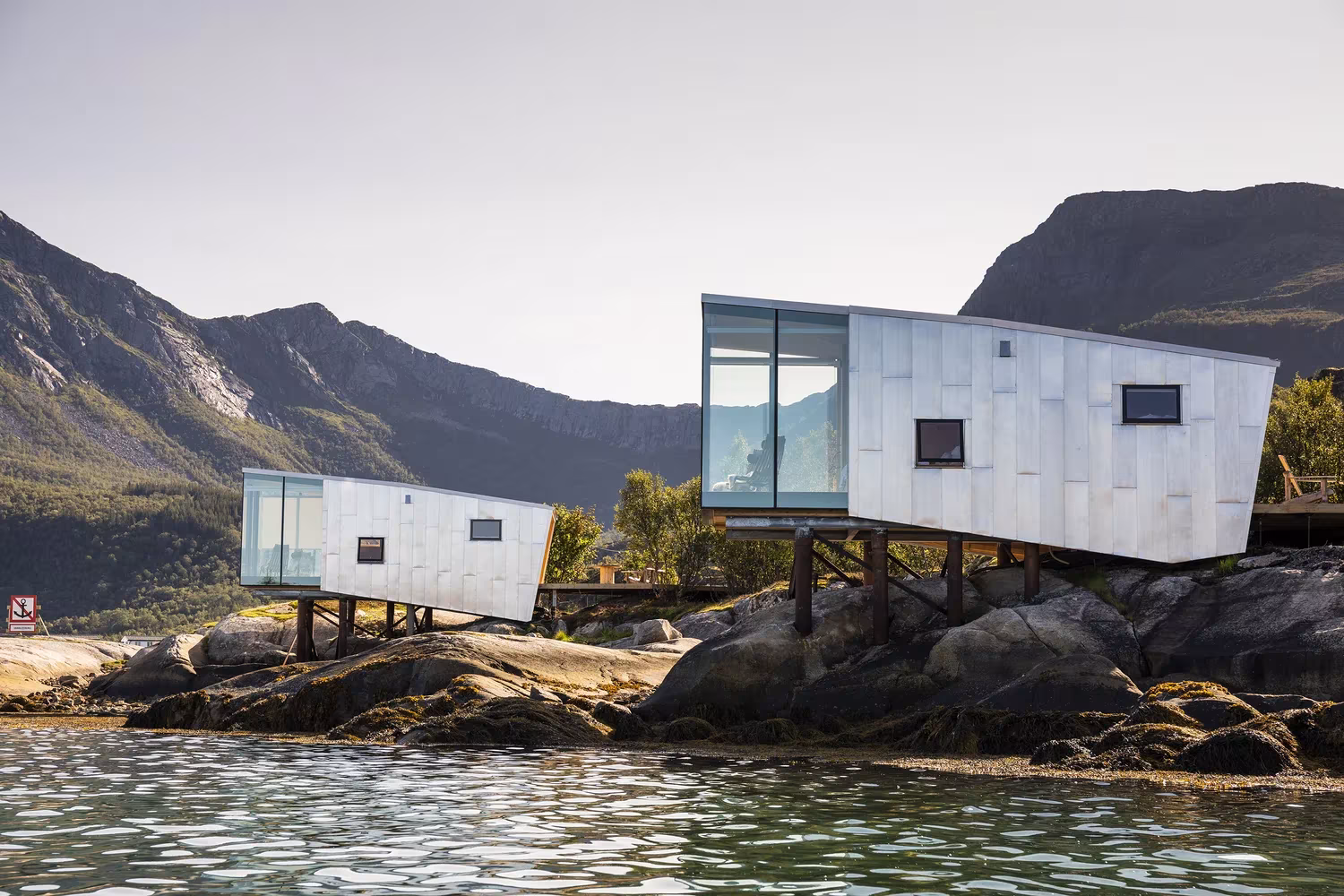 Cabañas de madera y cristal de Manshausen sobre pilotes entre rocas y montañas, de Stinessen Arkitektur, Noruega