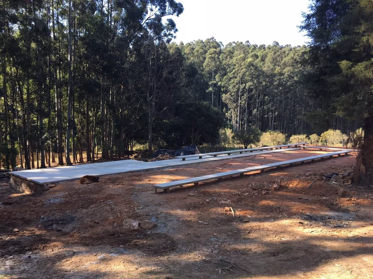 Solar de la Capilla Ingá-mirim durante la obra, con las cimentaciones sobre la tierra roja entre eucaliptos