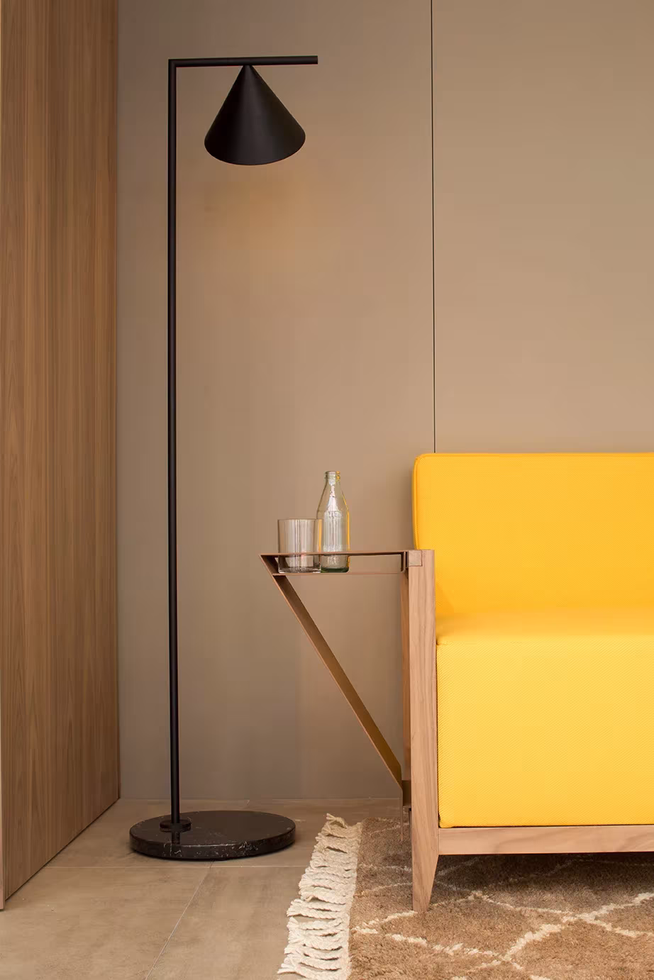Sillón amarillo y lámpara de pie negra junto al panelado de madera en la microcasa NO.MADE de ARC Studio Perlini