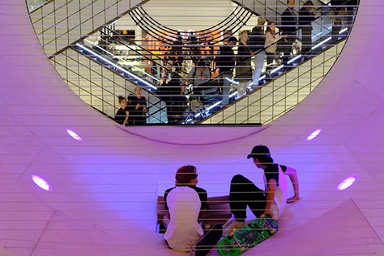 Le Cube, pista de skate acristalada de MANA en Le Bon Marché de París, vista desde arriba con jóvenes sentados