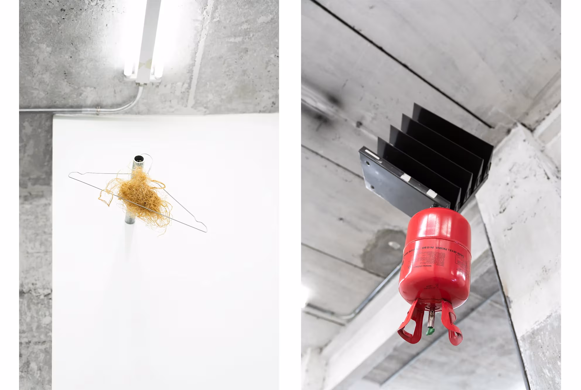 Instalación mínima de un manojo de paja suspendido y un extintor rojo bajo un techo de hormigón