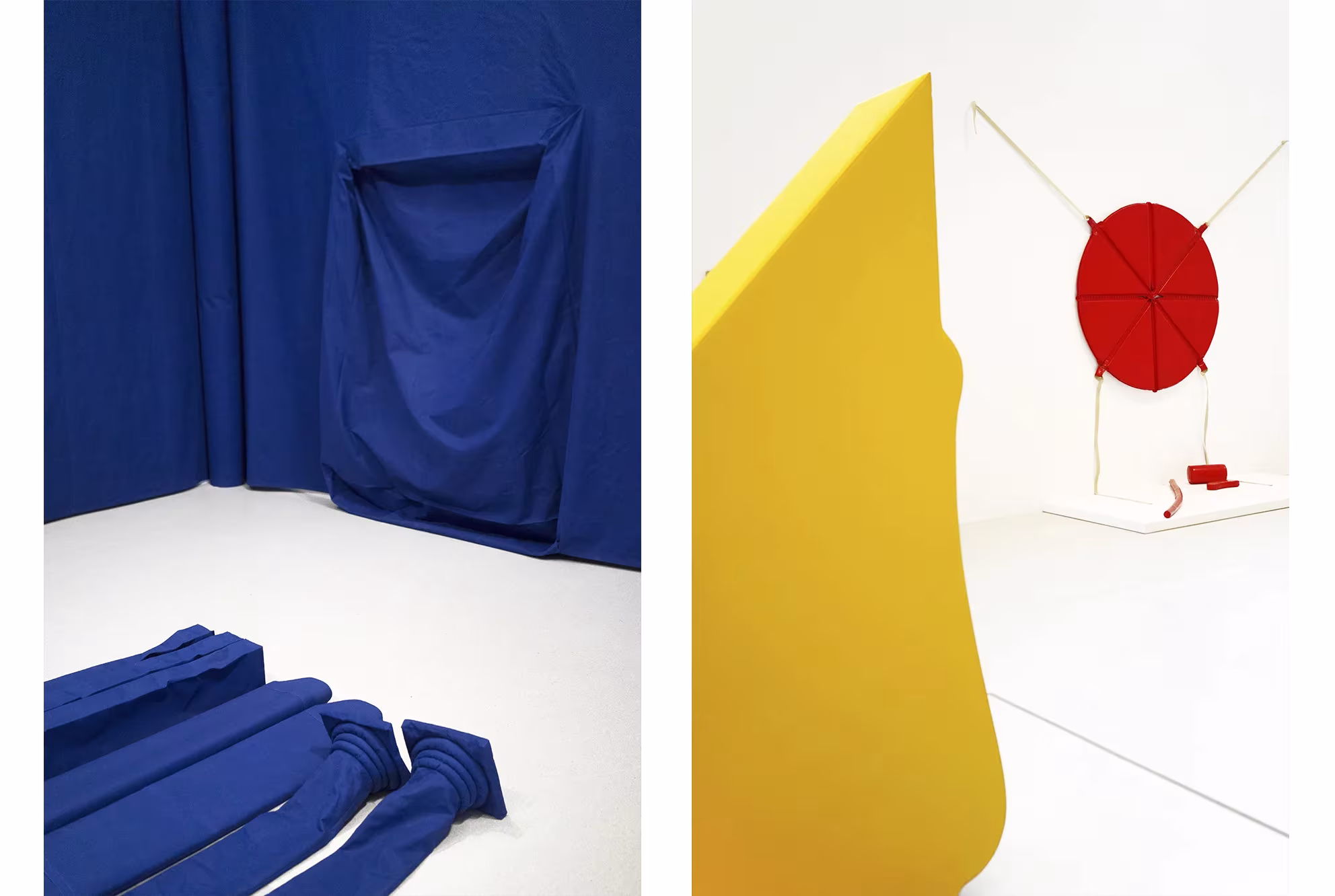 Instalación con telas azules sobre un muro blanco y una escultura amarilla con un disco rojo