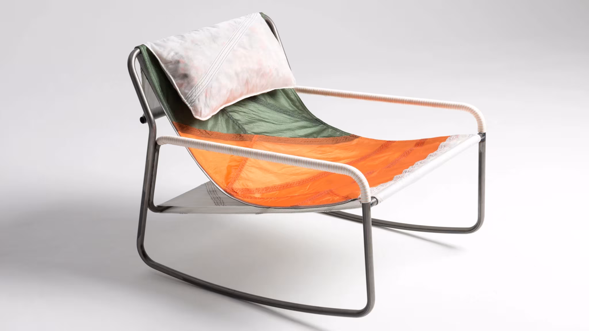 Mecedora Canopy con asiento de tela naranja y verde y cojín de paracaídas reciclado, de Layer y Raeburn