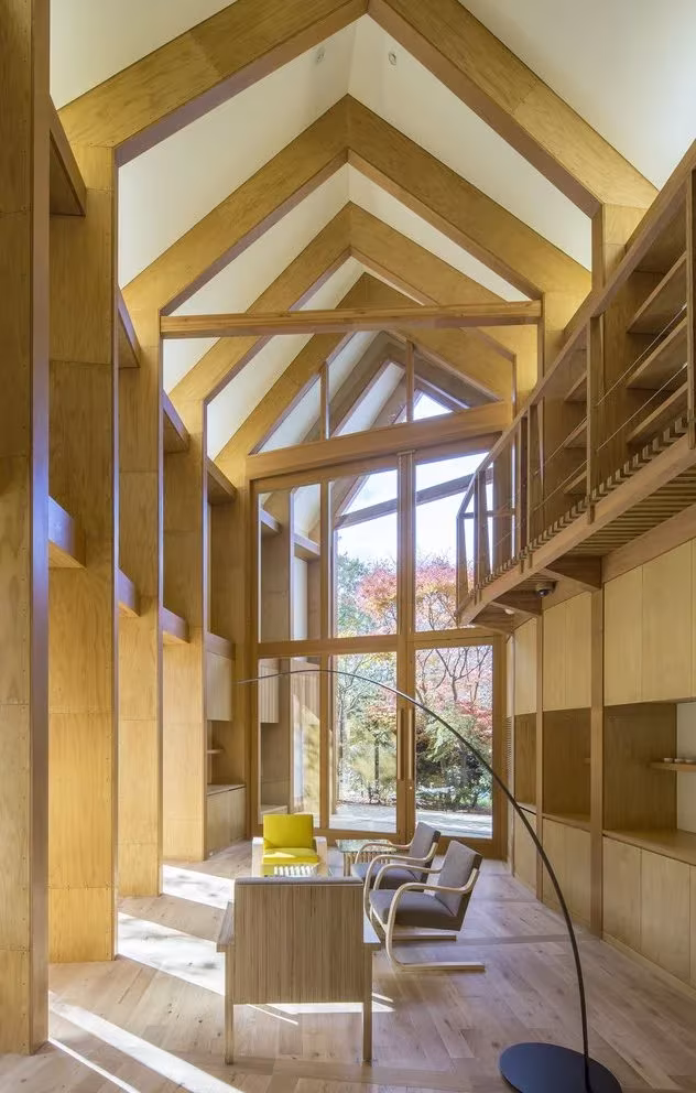 Interior de madera de Shishi-iwa con pórticos en forma de casa, estantes en altura y un ventanal al bosque