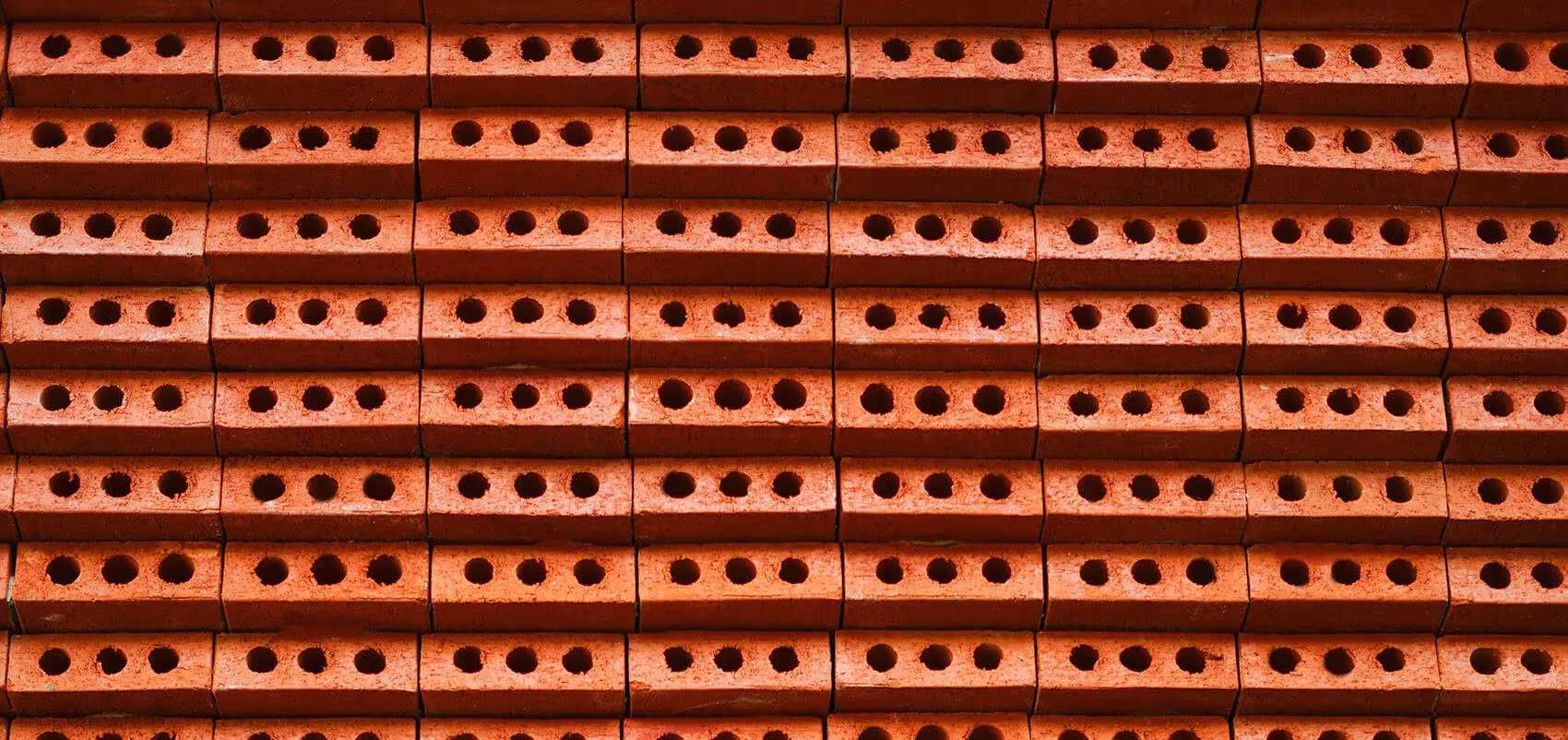 Primer plano de las hiladas de ladrillo cerámico perforado rojo que forman la fachada de la cafetería de GEOM Design