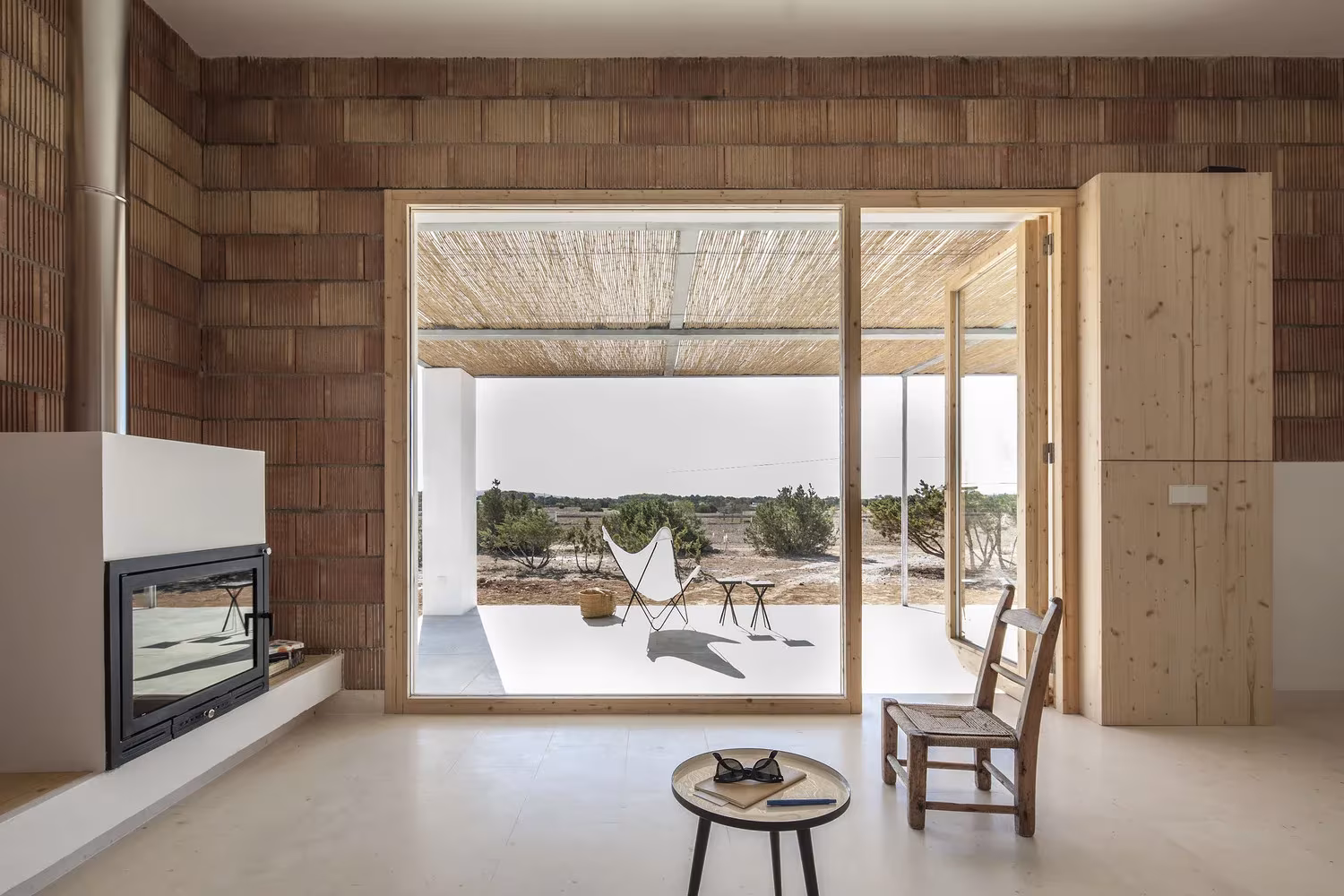 Chimenea blanca y puerta corredera hacia el porche en el salón de Can Xomeu Rita, en Formentera