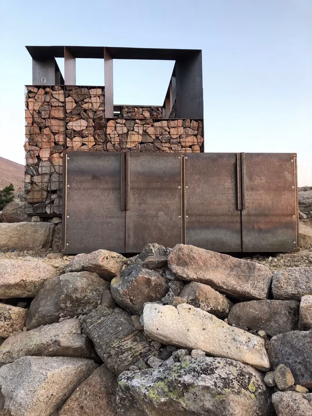 Aseo de gaviones con puerta de acero y cubierta volada entre bloques de roca en el Longs Peak, Colorado