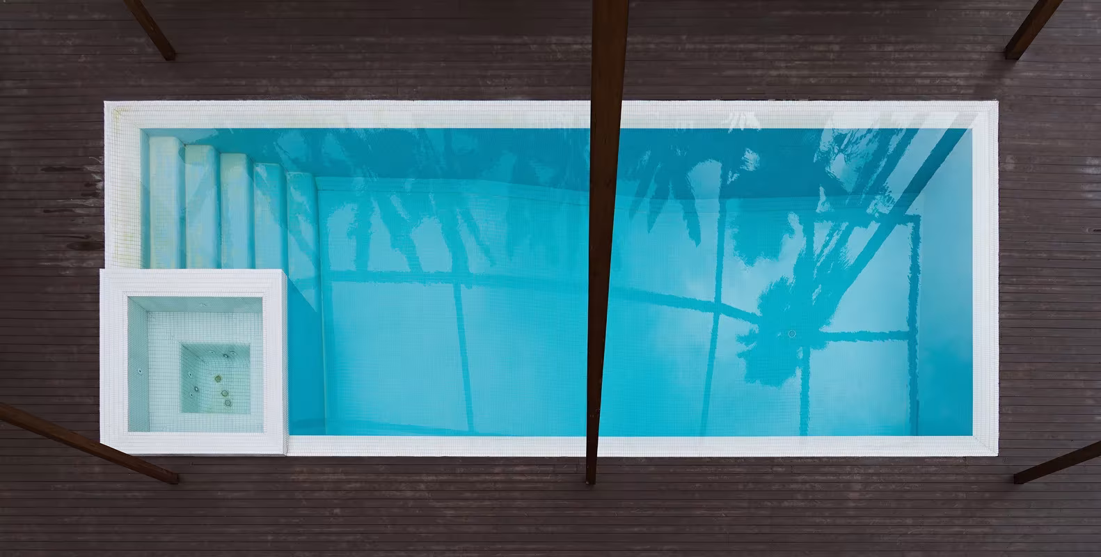 Piscina de Villa Vanoosh vista desde arriba, con el entramado de madera proyectando sombras sobre el agua