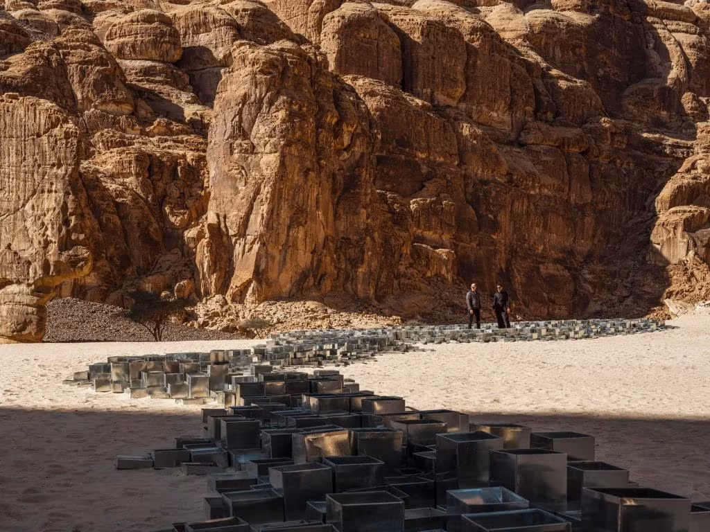 Módulos metálicos escalonados que dibujan un cauce seco al pie de un acantilado de AlUla, Desert X
