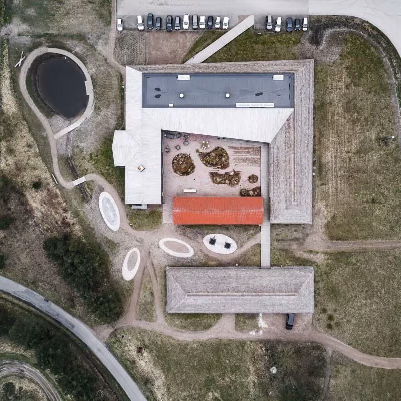 Vista aérea del centro del Mar de Wadden de Dorte Mandrup, con cubiertas de paja en torno a un patio central en Esbjerg