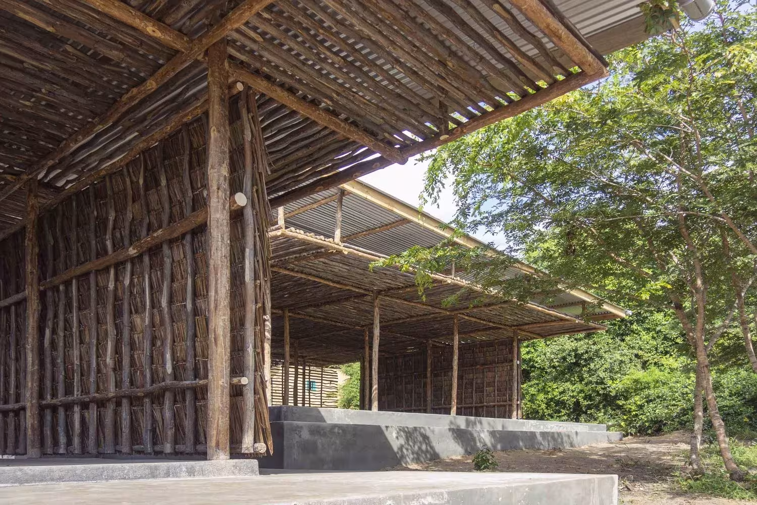 Estructura de postes de madera y cerramiento de hojas de coco en el Eco Moyo Education Center, Kenia