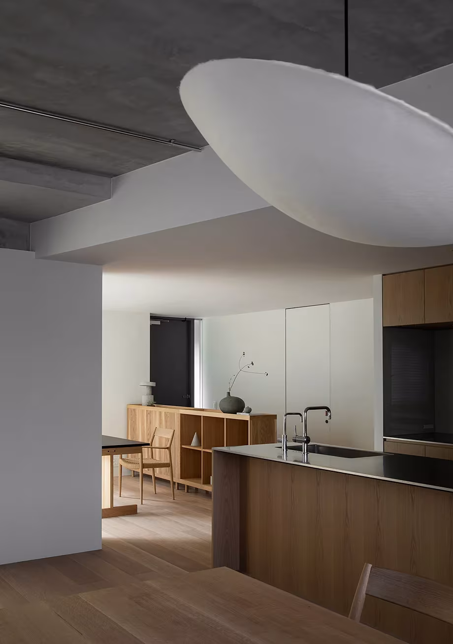 Cocina de Kinuta Terrace con isla de madera, falso techo curvo blanco y suelo de roble, de Norm Architects