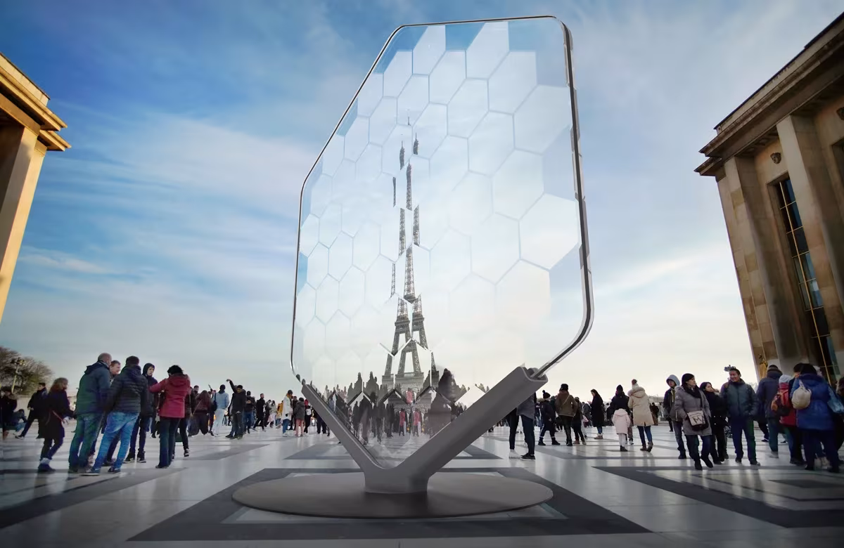 Lupa gigante hexagonal de Les Grands Kaléidoscopes junto al Trocadéro, con la Torre Eiffel reflejada en sus celdas