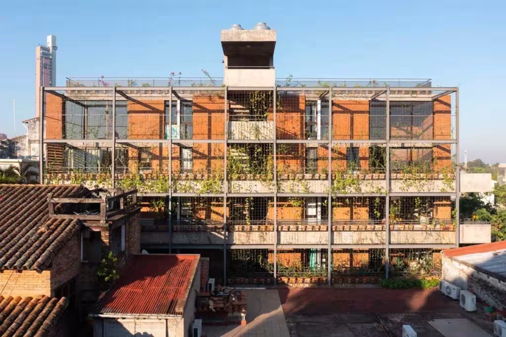 Fachada del edificio Valois de José Cubilla en tierra compactada, con estructura metálica y plantas en las terrazas