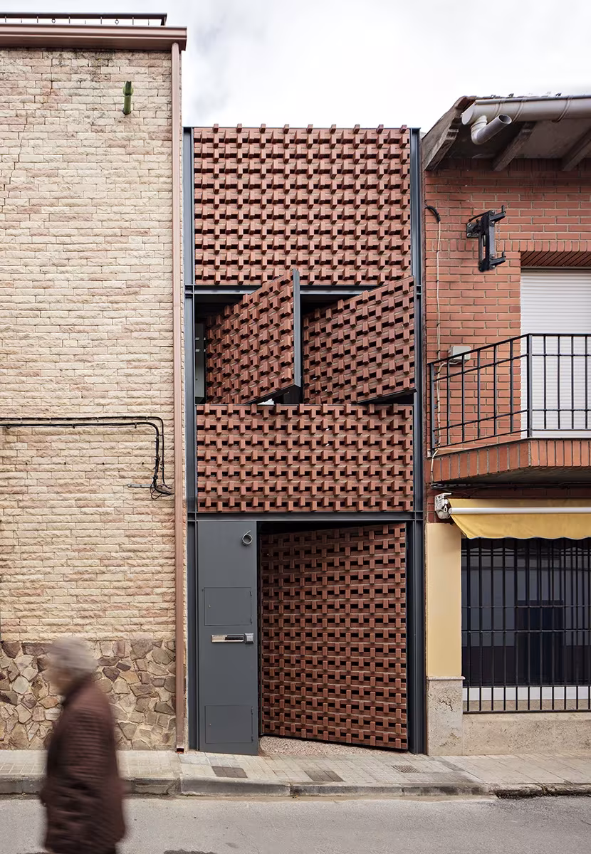 Cortina cerámica de Casa Piedrabuena con paneles móviles abiertos sobre el acceso, en Ciudad Real