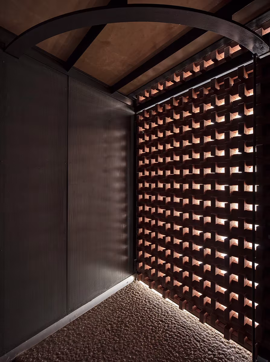 Celosía cerámica de piezas huecas vista desde el interior con luz rasante en Casa Piedrabuena