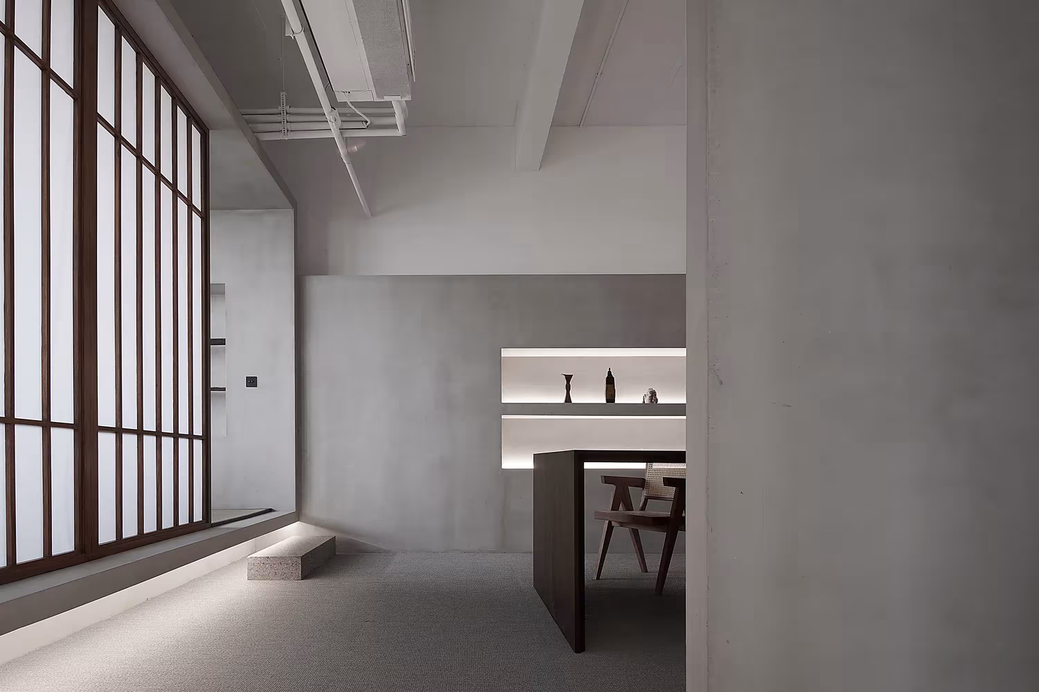 Sala con grandes paneles de celosía de madera y papel junto a un mostrador oscuro en el Estudio Resee