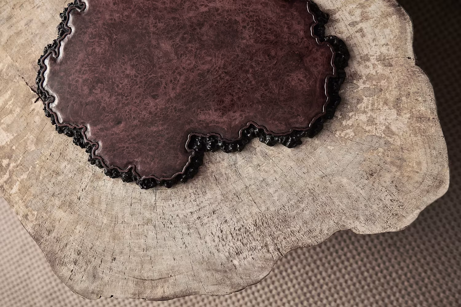 Pieza de madera con núcleo oscuro pulido y bordes naturales, detalle de las esculturas del Estudio Resee