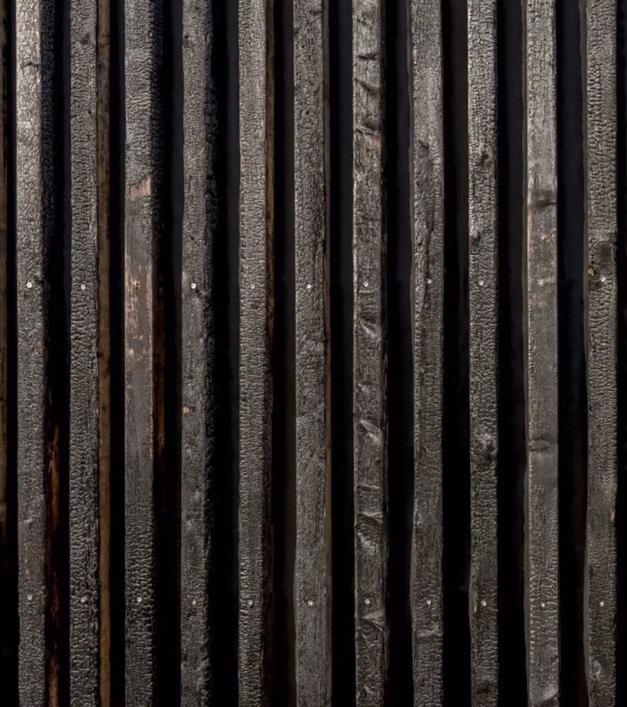 Detalle de los listones de madera carbonizada que revisten las cabañas de PK Arkitektar en Islandia