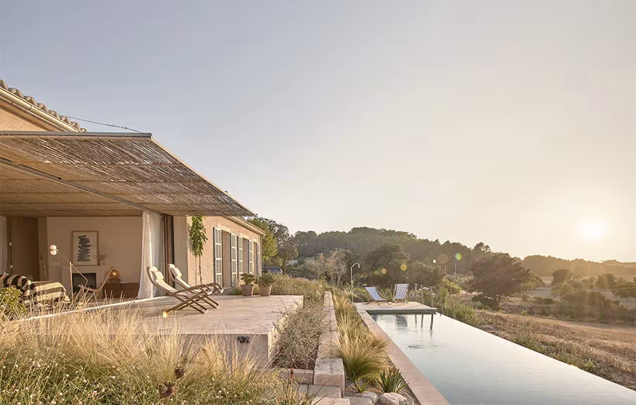 Casa Palerm de OHLAB al amanecer, con porche de cañizo y piscina alargada frente al campo mallorquín