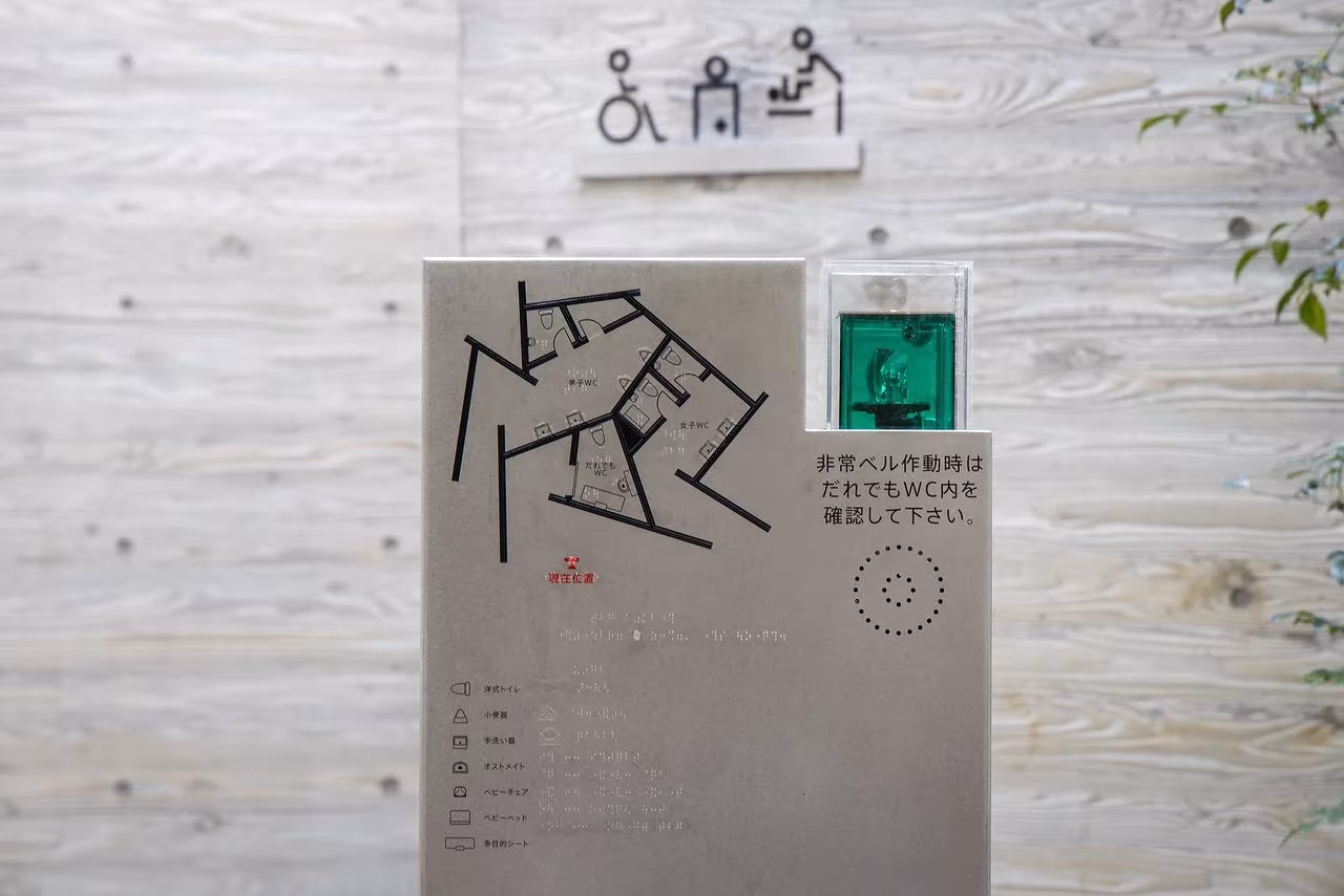 Letrero con el plano de la instalación y luz de emergencia en un baño público de Tokio