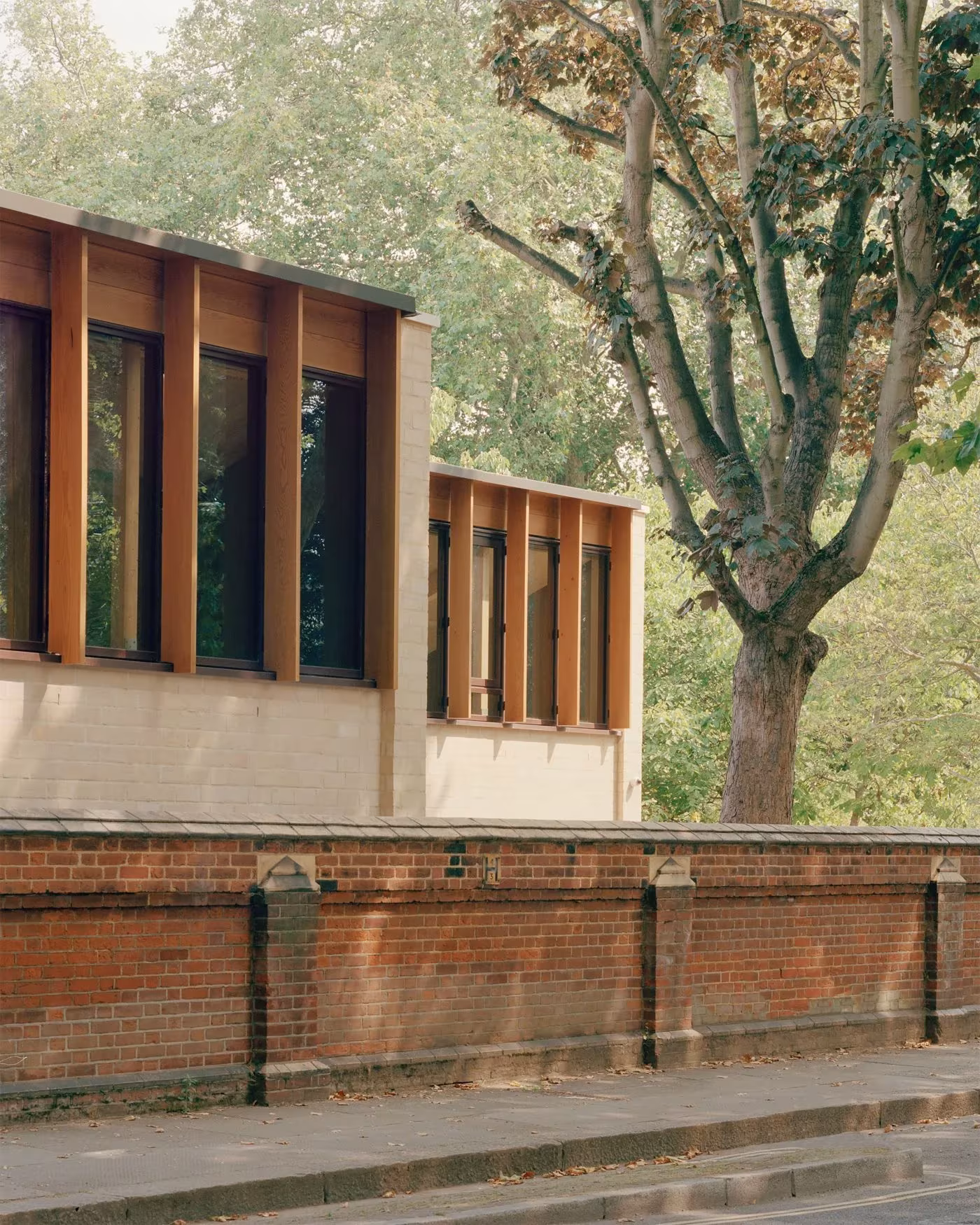 Fachada del Sands End Centre con ventanas enmarcadas en madera sobre un muro de ladrillo rojo