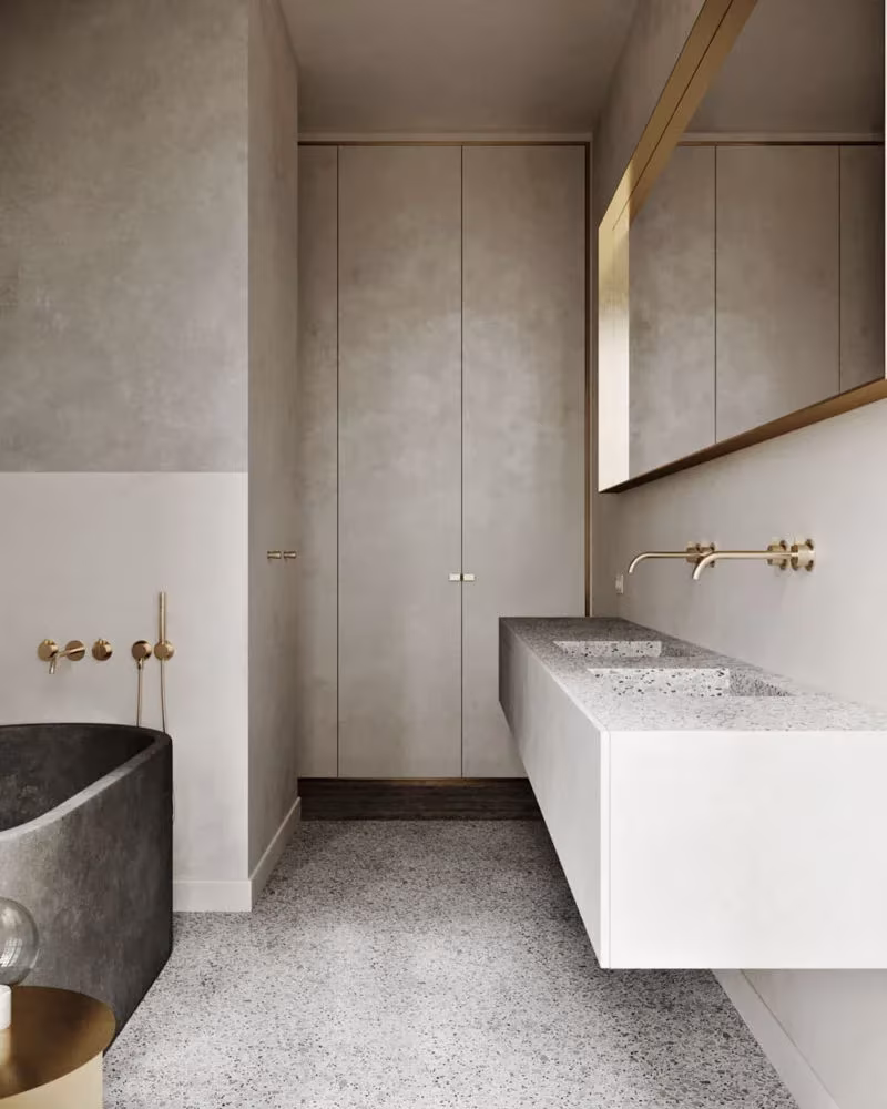 Baño del proyecto Sense con bañera de piedra oscura, lavabo blanco alargado y armarios empotrados