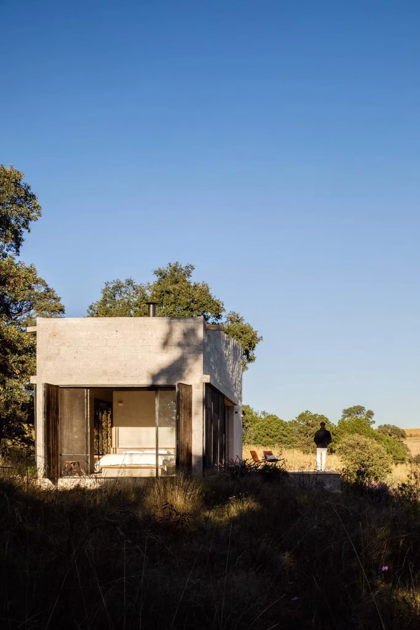 Refugio de Aculco de Pérez Palacios Arquitectos, cubo de piedra clara abierto al campo bajo cielo azul