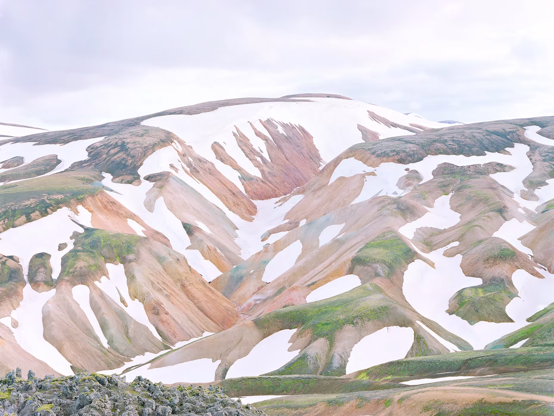 Montañas de suelo coloreado con manchas de nieve en un paisaje de altura, fotografía de Luca Tombolini