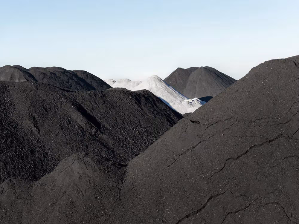Montículos de carbón negro en un parque industrial, fotografía de Guillermo Santos