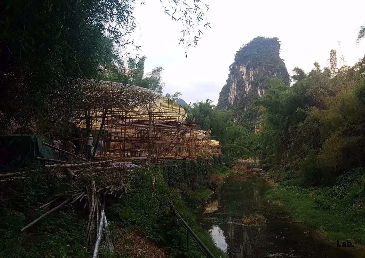 Estructura de bambú de LLLab. durante su montaje junto a un arroyo y un monte kárstico, en Yangshuo