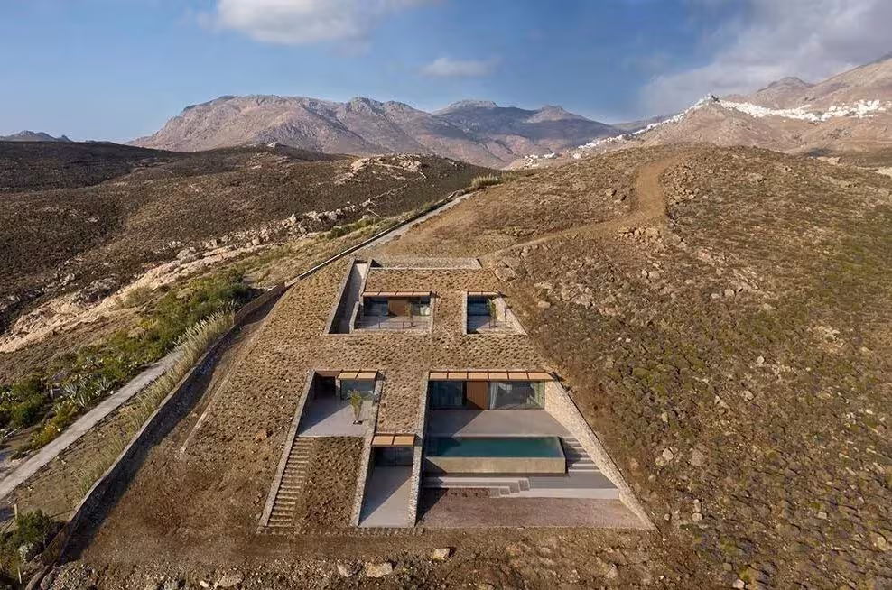 Casa NCaved semienterrada en la ladera de Serifos, con patios y piscina entre montañas