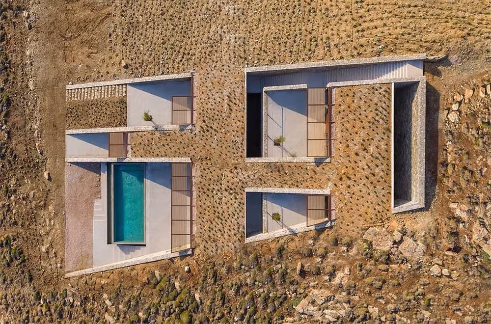 Vista cenital de la Casa NCaved: patios rectangulares y piscina recortados en el terreno árido