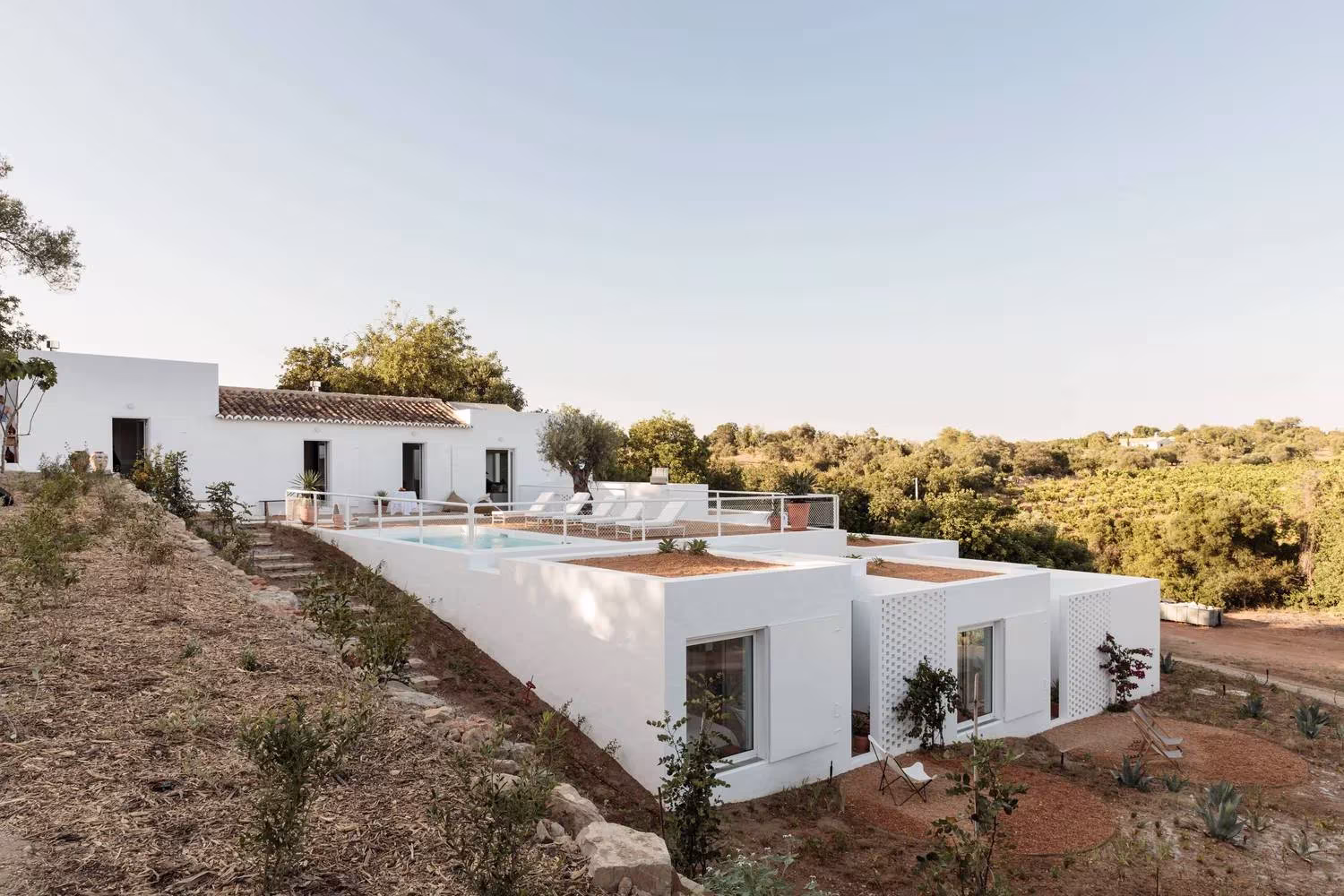 Volúmenes blancos escalonados de la Casa UM con la piscina sobre la ladera, obra de Atelier Rua en el Algarve