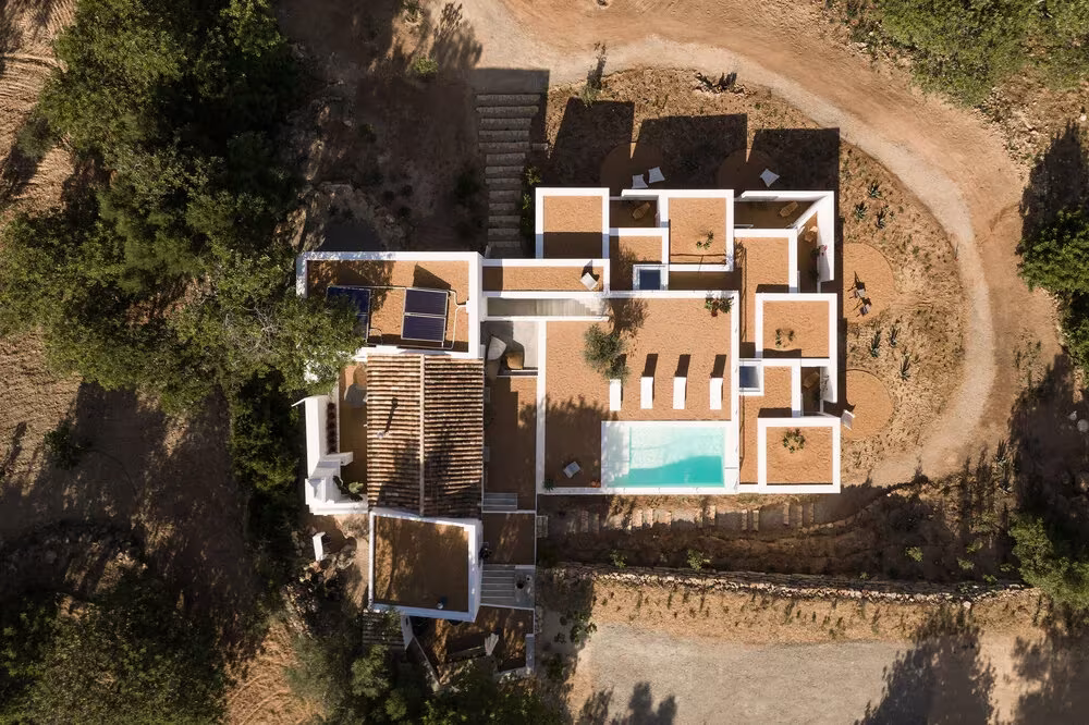 Vista cenital de la Casa UM con sus patios, la piscina y el camino de tierra rojiza
