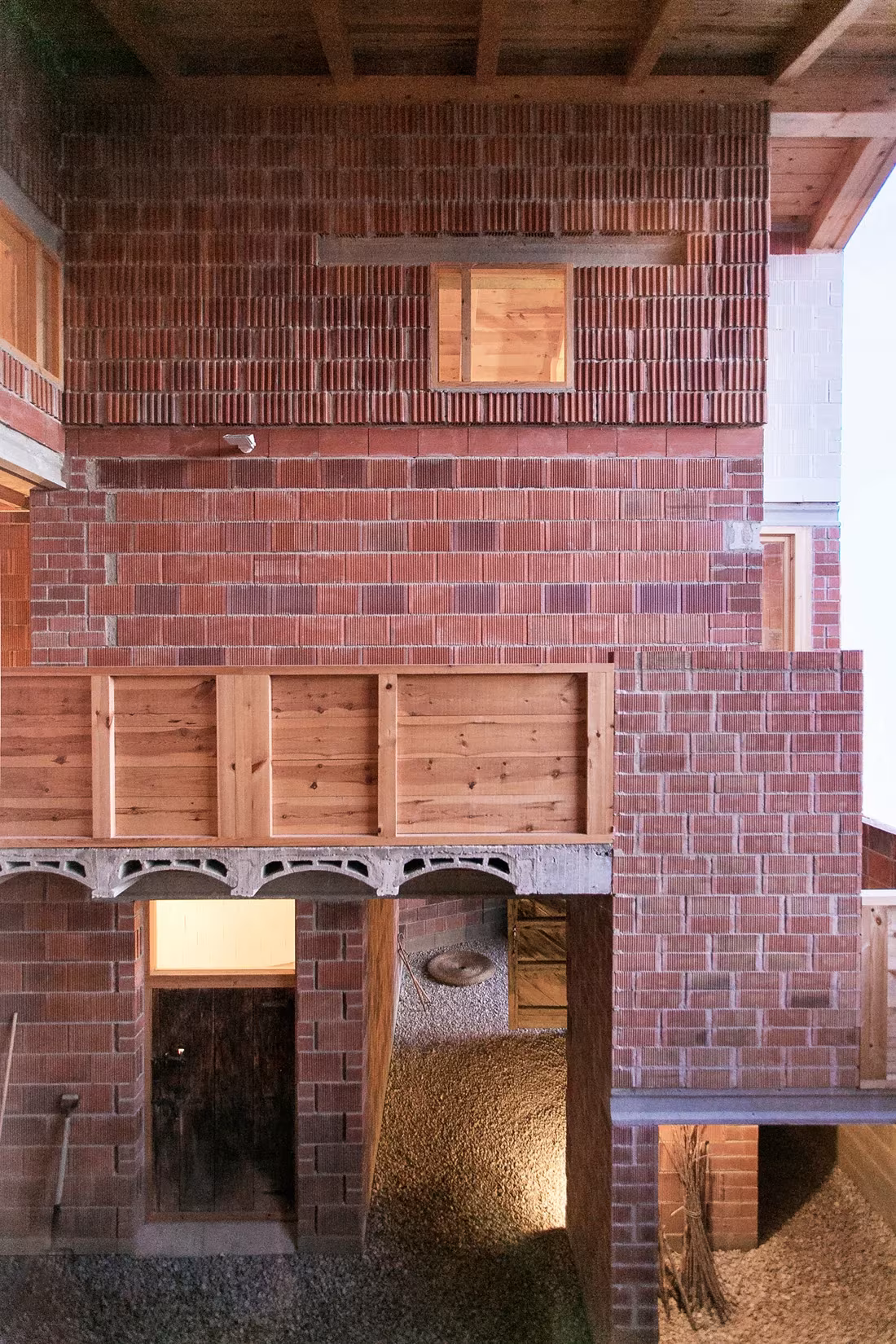 Patio con galería de madera y paños de ladrillo rojo en la Casa en Tres Primaveras de Teruel