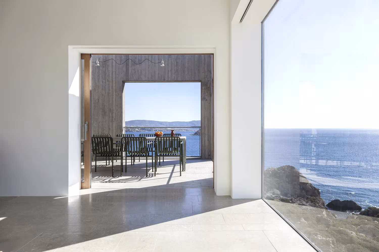 Estar de la Casa Patio abierto con un gran vidrio al mar y a la terraza comedor
