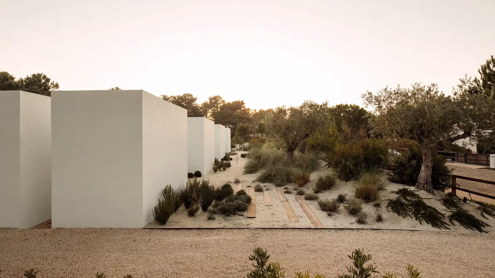 Volúmenes blancos de una planta de Comporta 10 entre dunas con matorral y pinos al atardecer