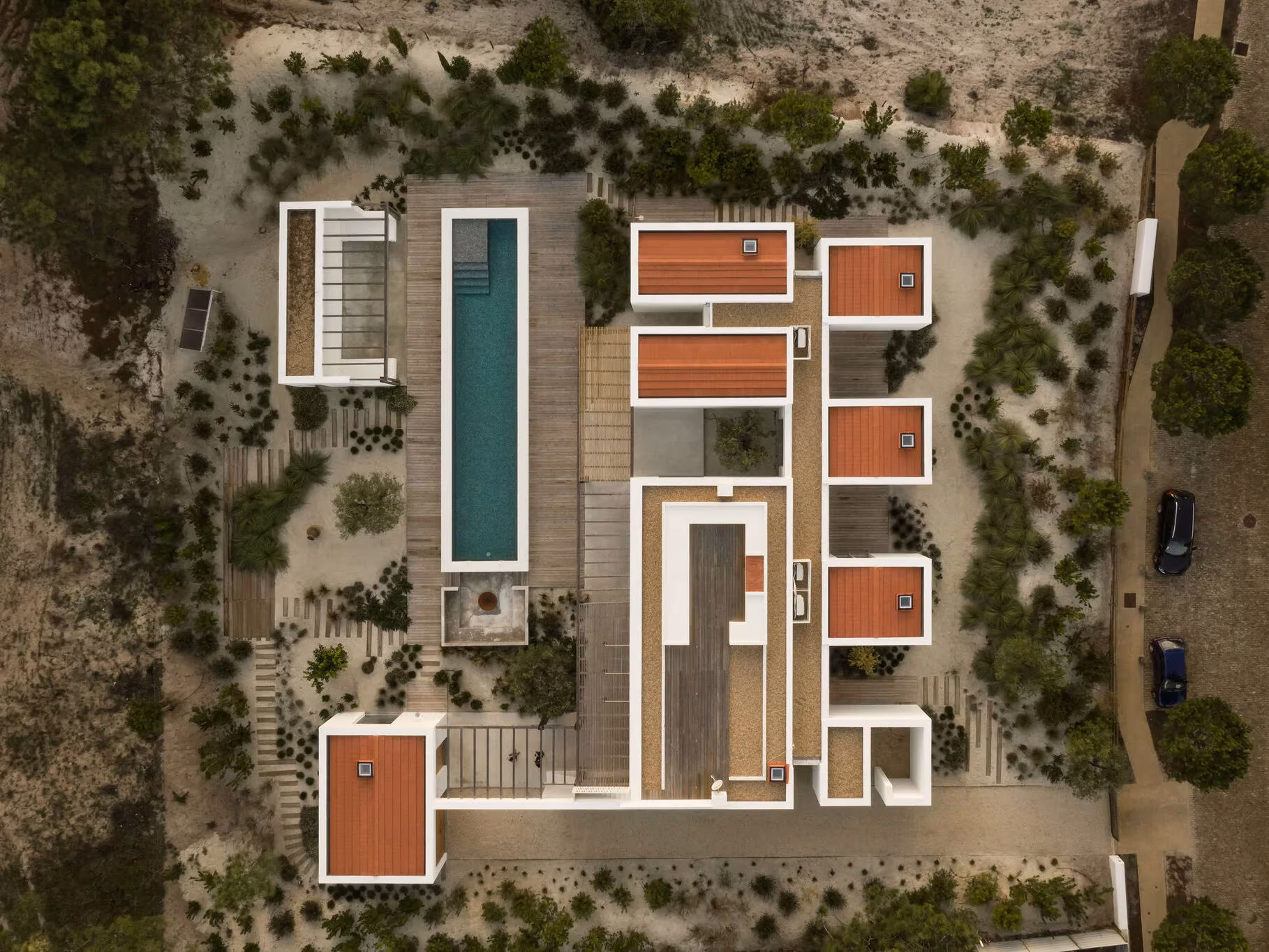 Vista aérea de Comporta 10 de Fragmentos de Arquitectura, con piscina y diez volúmenes entre vegetación