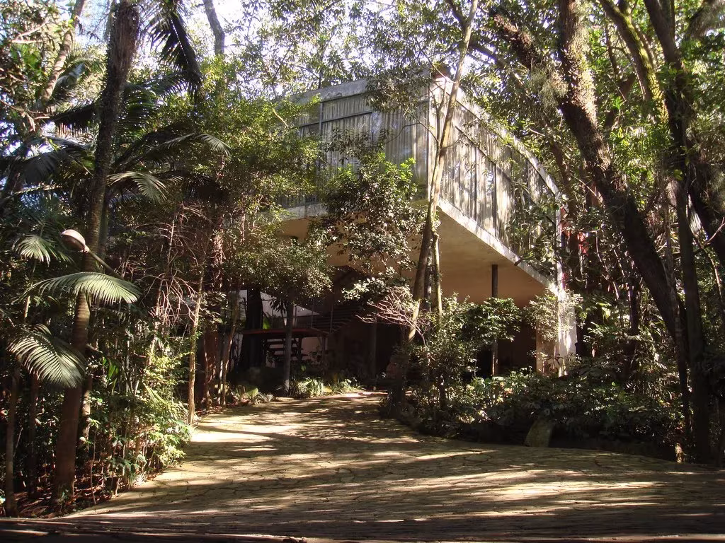 Camino entre vegetación tropical hacia la Casa de Vidro de Lina Bo Bardi en São Paulo